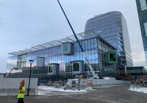 A construction worker walks near the building.