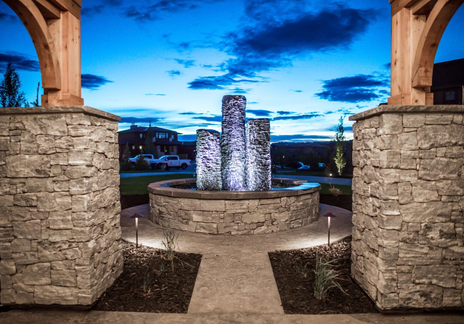 A fountain in the middle of a courtyard at dusk.